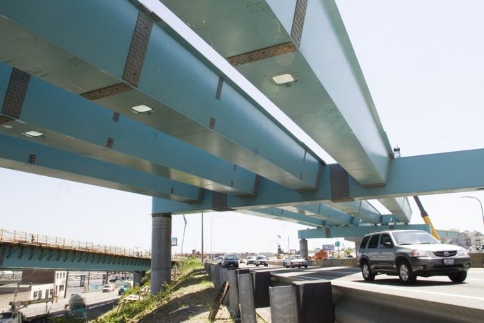 TRAFFIC zips along last week beneath the ramps being constructed to link I-95 to the new I-195 as part of the Iway project. / 