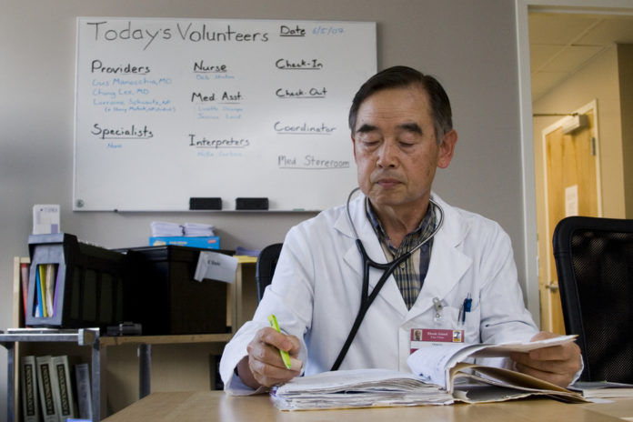 DR. CHANG LEE, a retired surgeon, volunteers at the Rhode Island Free Clinic twice a month. The clinic, which serves about 1,600 uninsured patients, has a large new facility, but not enough volunteers to meet a fast-rising demand for services. / 