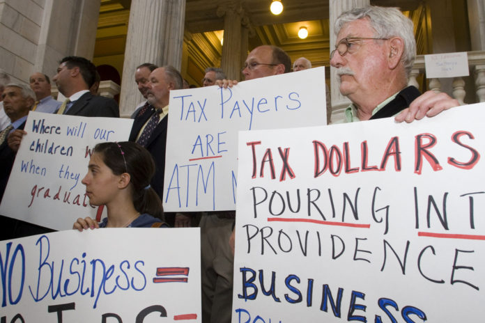 BUSINESS LEADERS protest some of legislators' budget choices at a State House rally last week. / 