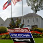 A sign advertising an open house for a home under foreclosure and slated for auction is posted in a yard in Decatur, Georgia. / 