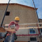 WORKERS INSTALL SIDING on a home under construction in Erie, Colo. U.S. builders started work on an unexpectedly high number of homes in June. / 