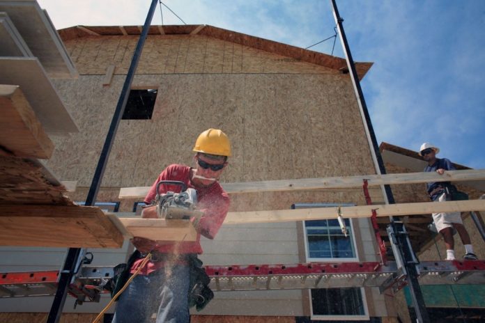 WORKERS INSTALL SIDING on a home under construction in Erie, Colo. U.S. builders started work on an unexpectedly high number of homes in June. / WORKERS INSTALL SIDING on a home under construction in Erie, Colo. U.S. builders started work on an unexpectedly high number of homes in June. /