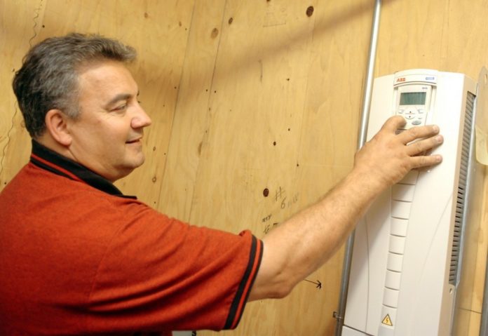 Dryvitt Plant Manager Gary Ridenour points out the new electrical system that the company is putting into place to help reduce electricity consumption. With the help of National Grid they have reduced consumption by almost 40 percent. / Dryvitt Plant Manager Gary Ridenour points out the new electrical system that the company is putting into place to help reduce electricity consumption. With the help of National Grid they have reduced consumption by almost 40 percent. /