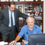DR. ALBERT J. PUERINI JR., one of the owners and founders of Polaris, demonstrates the EpiChart software as Noah Benedict, executive director of the company, looks over his shoulder. / 