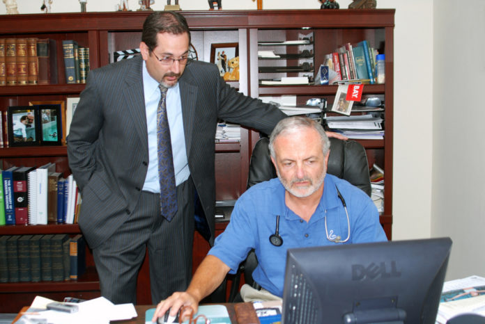 DR. ALBERT J. PUERINI JR., one of the owners and founders of Polaris, demonstrates the EpiChart software as Noah Benedict, executive director of the company, looks over his shoulder. / 