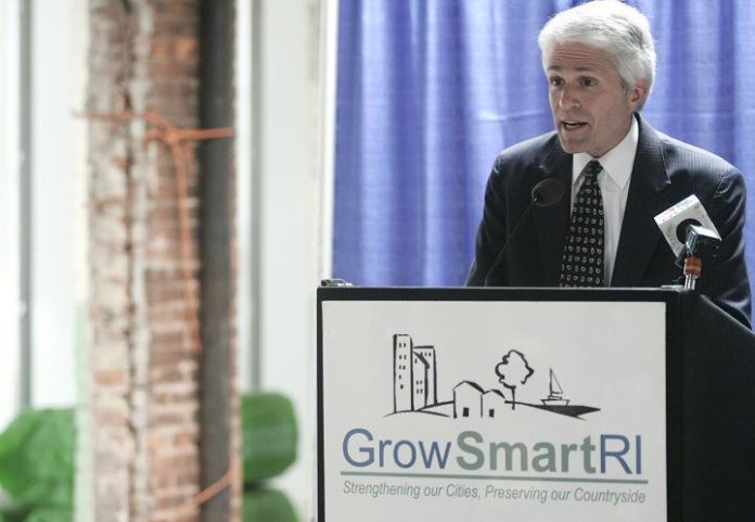 SCOTT WOLF, executive director of Grow Smart Rhode Island, speaks at a press conference on the historic tax credit at Hope Artiste Village last week. / 