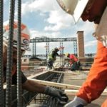 DECLINES IN SPENDING on public and private residential construction in September were offset by increases in nonresidential projects, the Census Bureau found. Workers in Denver yesterday install rebar for beam pockets on the fifth floor of an apartment building. / 