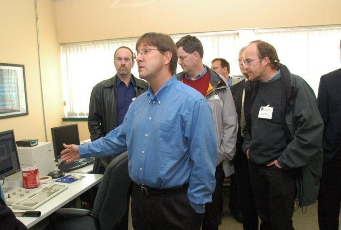 MICHAEL PLATEK, an electrical engineer at URI, shows a group of scientists and engineers around the lab of the school’s Surface and Sensors Technology Partnership. / 