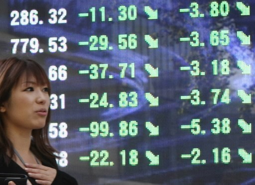 STOCK PRICES FELL around the world today. Above, a woman walks past a stock ticker board at midday in Tokyo, where the Nikkei 225 index lost 2 percent today. / STOCK PRICES FELL around the world today. Above, a woman walks past a stock ticker board at midday in Tokyo, where the Nikkei 225 index lost 2 percent today. /