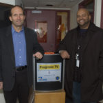 Startup looks to provide digital signs for just $500 ENTREPRENEUR John Zib, left, shows off one of his electronic displays at Progreso Latino in Central Falls. With him is George Ortiz, chief operating officer of the nonprofit. /
