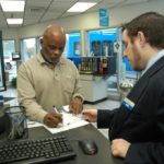 ONLY 34 percent of respondents to a recent survey said they purchased insurance when renting a car. Above, Thomas Williams fills out paperwork to rent a car at Thrifty Car Rental in Warwick last week. / 