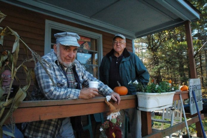 CLARK WHITFORD, right, whose son Jason runs the Blueberry Hill Store in Exeter, stands on the porch with customer Larry Fortin. / CLARK WHITFORD, right, whose son Jason runs the Blueberry Hill Store in Exeter, stands on the porch with customer Larry Fortin. /