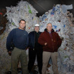 SORTING THROUGH THE JUNK: From left, Adam, Sam and Charlie Sinel of Berger & Co. Recycling Inc. stand near a pile of materials slated to be recycled. The company today buys recyclables and sells them on the global commodities market. / 