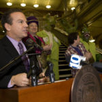 MAYOR DAVID N. CICILLINE speaks at the Dec. 21 press conference announcing the lineup for Bright Night Providence, while Adam Gertsacov, Bright Night festival director, and Big Nazo puppets and team listen. / 