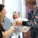 Birthing takes on personal touch CHRIS GESALDI, right, a nurse at Memorial Hospital of Rhode Island, hands day-old Ella to her mother, Rebecca Lamonte of Pawtucket, on Wednesday, Nov. 27. /