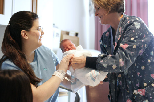 CHRIS GESALDI, right, a nurse at Memorial Hospital of Rhode Island, hands day-old Ella to her mother, Rebecca Lamonte of Pawtucket, on Wednesday, Nov. 27. / CHRIS GESALDI, right, a nurse at Memorial Hospital of Rhode Island, hands day-old Ella to her mother, Rebecca Lamonte of Pawtucket, on Wednesday, Nov. 27. /