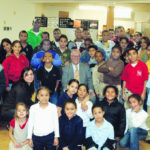 JWU PRESIDENT Irving Schneider and students Ellyn Gerrmann, to his left, and Donte Noble, at the back in green, are surrounded by children at South Providence Neighborhood Ministries. / 