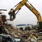DEMOLITION CREWS work to tear down the final two Navy barracks at Quonset Business Park last month. / 