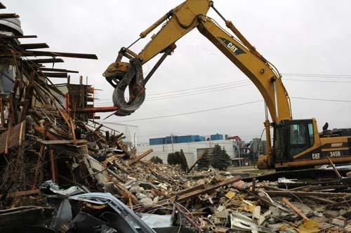 DEMOLITION CREWS work to tear down the final two Navy barracks at Quonset Business Park last month. / DEMOLITION CREWS work to tear down the final two Navy barracks at Quonset Business Park last month. /