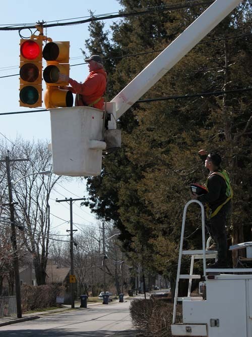 A CITY WORKER IN Warwick replaces old incandescent bulbs in traffic lights with energy efficient LED bulbs to meet standards set by an EPA challenge. / A CITY WORKER IN Warwick replaces old incandescent bulbs in traffic lights with energy efficient LED bulbs to meet standards set by an EPA challenge. /