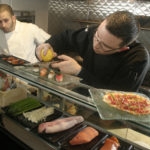 Asian fare
finds home
with flair CHINESE LAUNDRY Executive Chef Nick Rabar applies lemon zest to sushi as he and Sous Chef Luis Cruz prepare for the resturant's opening at 121 North Main St. /