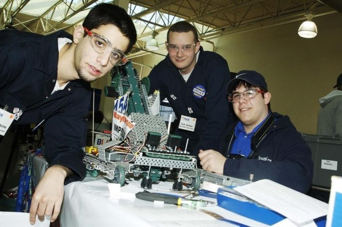 BURRILLVILLE HIGH team members show off their robot. They and the other top R.I. teams, from Tiverton High and The Met School, will advance to the international competition. / 