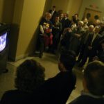 THE OVERFLOW CROWD of concerned taxpayers crowds the hallway outside the basement hearing room to watch the proceedings via closed-circuit TV. / 