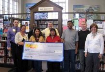 Martin Elizardo, Providence Wal-Mart store manager, left, and Carol Moore, assistant manager, second from left, present a $10,000 Wal-Mart donation to RIFLI Program Coordinator Karisa Tashjian, right, and members of the RIFLI Workplace Communications class. /