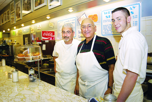 from left, Peter, Michael and Shane Rufful work behind the counter at the family-owned diner, one of the oldest businesses in the neighborhood. / from left, Peter, Michael and Shane Rufful work behind the counter at the family-owned diner, one of the oldest businesses in the neighborhood. /