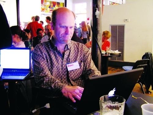 BRIAN JEPSON, a co-founder of the Providence Geeks, works on his laptop at a recent Geeks dinner at AS220. The monthly events now draw about 100 people each. / BRIAN JEPSON, a co-founder of the Providence Geeks, works on his laptop at a recent Geeks dinner at AS220. The monthly events now draw about 100 people each. /