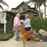 IN THE WEST, the pending sales index rose 8.3% compared with March and 4.0% compared with April 2007, the NAR said. Year-over-year declines were seen in the other three regions, though only the Northeast fell compared with March. Pausing outside a home in San Diego are house-hunters Bob and Georgia Grieser with their golden retriever, Buster. / 