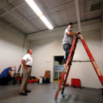 LEAN MANUFACTURING: Geoff Grove, on ladder, checks the progress of work aimed to improve Pilgrin Screw. / 