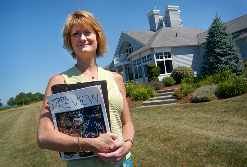LIZ TABER, a broker/manager for Gustave White Sotheby’s International Realty, in front of a recently purchased seaside home in Bristol. / LIZ TABER, a broker/manager for Gustave White Sotheby’s International Realty, in front of a recently purchased seaside home in Bristol. /