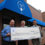 MICHAEL ANDRADE, of The Arc of Northern Bristol County, center, accepts a $5,000 check from Attleboro Area Chamber of Commerce President Jack Lank, left, and 10th Annual Charity Open Golf Committee Chairman Paul Leveillee of Sovereign Bank. / 