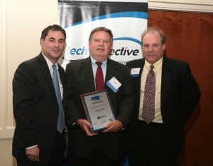 Former RI Economic Development Corporation Director Saul Kaplan(l) and PBN Editor Mark Murphy(r) present Chris Crawford, of TCMPi, with his Innovation Award for being the Innovator of the Year. / PBN Photo