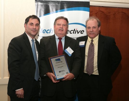 Former RI Economic Development Corporation Director Saul Kaplan(l) and PBN Editor Mark Murphy(r) present Chris Crawford, of TCMPi, with his Innovation Award for being the Innovator of the Year. / PBN Photo