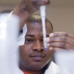 ADEMOLA JONAH, a student in the URI Biotechnology manufacturing program, works in the school’s Providence laboratory. / 