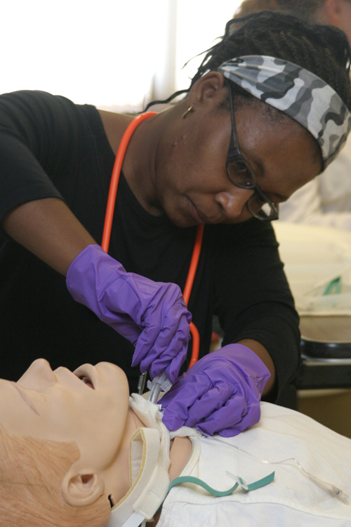 HANDS-ON TRAINING: Anne Duré, of Providence,
performs a tracheotomy on the SIM Man, a mannequin
at CCRI. / HANDS-ON TRAINING: Anne Duré, of Providence,
performs a tracheotomy on the SIM Man, a mannequin
at CCRI. /