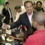 UP AND RUNNING: Providence Mayor David N. Cicilline assists children in the GTECH After School Advantage computer lab during the festive re-opening of Elmwood Community Center. / 