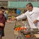 HOMEGROWN: Brian Kingsford, chef and owner of Bacaro, serves grilled pizza to Al Brown at Confreda Farms in Cranston. / 
