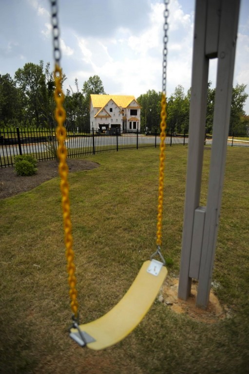 ON HOLD: An unfinished house looks next to a playground in an unfinished neighborhood in Forsyth, Ga. / ON HOLD: An unfinished house looks next to a playground in an unfinished neighborhood in Forsyth, Ga. /