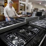 CONSUMER PURCHASES of durable goods such as cars and major appliances fell 2.9% last month, while purchases of non-durable goods fell 0.8%, the BEA said. Above, Todd Malone of Berkeley, Calif., looks at kitchen ranges this spring in the local General Appliance & Kitchen store.  / 