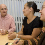 Cox Communications Senior Vice President and General Manager Paul Cronin, left, talks with Community Relations Coordinator Rosaura Fernandez, center, and Community Relations Manager Ana Paiz. / 