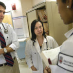 DRS. CURT BECKWITH and Susan Cu-Uvin review a patient's file with medical student Nadine Harris, foreground. / 