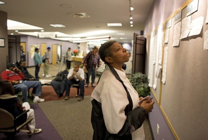 ANALYSTS BLAMED the effect of the Christmas and Hannukah holidays for the decline in new unemployment claims in the week ended Dec. 27. Above, Colorado resident Florine Wilburn, right, checks the job boards at a state Workforce Center in Denver earlier this month.  / 