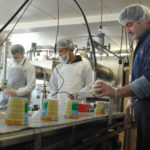 ALL IN THE FAMILY: Warwick Ice Cream C. Vice President Tom A. Bucci, right, checks a container of Berkshire Ice Cream on the production line at the Warwick facility. His son, Thomas Bucci, far left, is also an employee at the company. / 