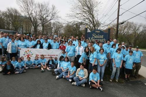 VOLUNTEERS FROM the Comcast Foundation gather around the entrance to St. Vincent’s in Fall River to celebrate the Comcast Day of Service. / VOLUNTEERS FROM the Comcast Foundation gather around the entrance to St. Vincent’s in Fall River to celebrate the Comcast Day of Service. /