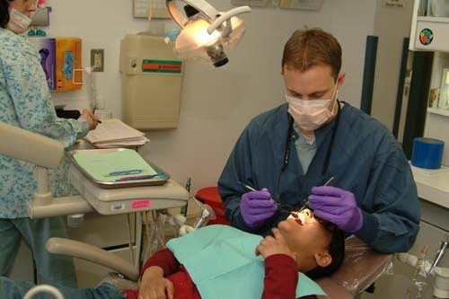 PULLING TEETH: St. Joseph Hospital’s pediatric dental resident Douglas Warner works on a patient. / PULLING TEETH: St. Joseph Hospital’s pediatric dental resident Douglas Warner works on a patient. /