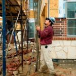 A CONSTRUCTION WORKER WORKS outside a home being built in Coppell, Texas, earlier this month. The number of monthly housing starts rose in May, but is still down 77 percent from its peak in 2006. / 