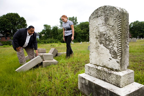 NEW LIFE: V. Darrell Waldron of the Rhode Island Indian Council examines toppled tombstones at the Locust Grove Cemetery with Amanda Hall. She is one of 14 people who will work this summer to help restore the run-down cemetery. / NEW LIFE: V. Darrell Waldron of the Rhode Island Indian Council examines toppled tombstones at the Locust Grove Cemetery with Amanda Hall. She is one of 14 people who will work this summer to help restore the run-down cemetery. /